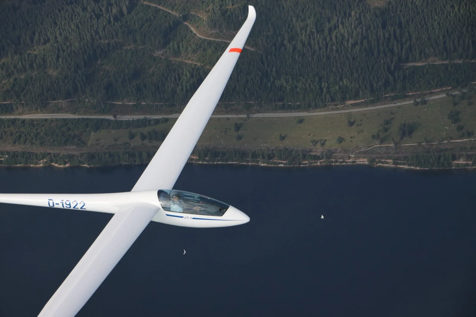 Segelflugzeug im Flug über einem See